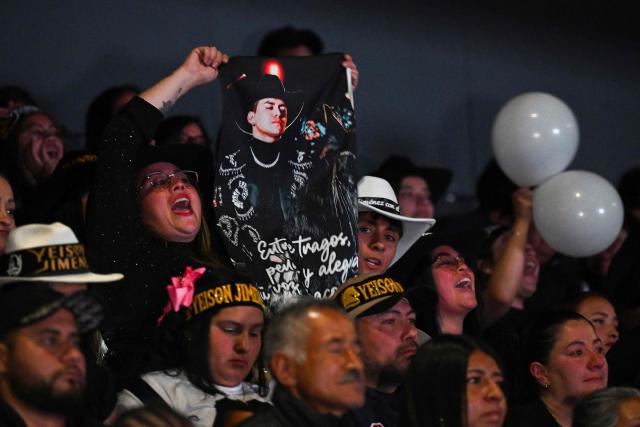 Fans of Colombian singer Yeison Jimenez attend the funeral honors for the artist in Bogota on January 14, 2026. Six people died on january 10, including popular singer Yeison Jimenez, when the small plane they were traveling in crashed shortly after takeoff in central Colombia, authorities said. (Photo by Raul ARBOLEDA / AFP)