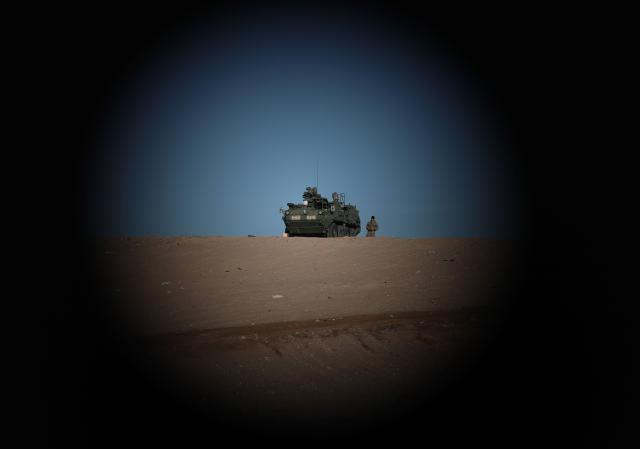 An US Army soldier stands next to an armored tank next to the US-Mexico border at Santa Teresa, New Mexico, US, as seen from Ciudad Juarez, Chihuahua state, Mexico on January 14, 2026. (Photo by Herika Martinez / AFP)