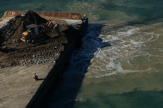 A construction crew works on the Pier G South Slip Fill project as seen from a crane on the ITS Terminal at the Port of Long Beach in Long Beach, California on January 14, 2026. (Photo by Patrick T. Fallon / AFP)