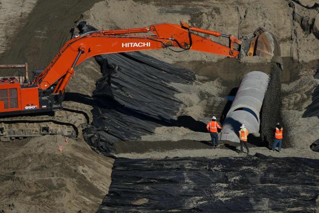 Construction crews work to install pipes on Pier G South Slip Fill project as seen from a crane on the ITS Terminal at the Port of Long Beach in Long Beach, California on January 14, 2026. (Photo by Patrick T. Fallon / AFP)