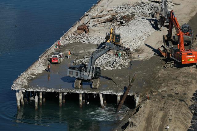 A demolition crew removes debris during on the Pier G South Slip Fill project as seen from a crane on the ITS Terminal at the Port of Long Beach in Long Beach, California on January 14, 2026. (Photo by Patrick T. Fallon / AFP)