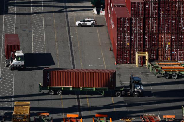 A truck moves a cargo shipping container as seen from a crane above the ITS Terminal at the Port of Long Beach in Long Beach, California on January 14, 2026. (Photo by Patrick T. Fallon / AFP)