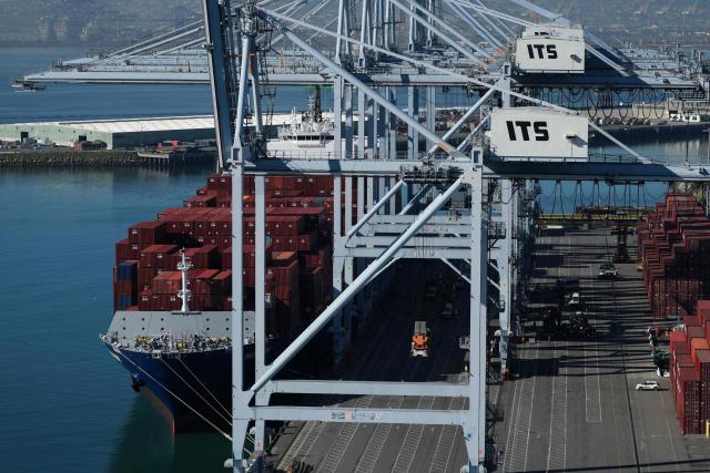 Cranes move cargo shipping containers from a ship on the ITS Terminal at the Port of Long Beach in Long Beach, California on January 14, 2026. (Photo by Patrick T. Fallon / AFP)