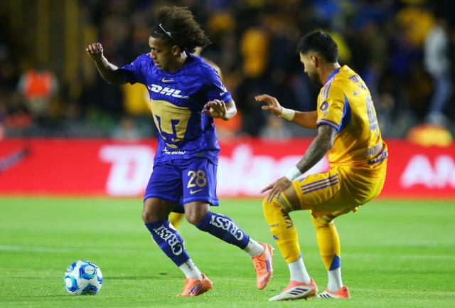 Pumas' Panamanian midfielder #28 Adalberto Carrasquilla and Tigres' defender #04 Juan Jose Purata fight for the ball during the Liga MX Clausura tournament football match between Tigres and Pumas at the University  Stadium (UANL) in San Nicolas de los Garza, Mexico on January 14, 2026. (Photo by Julio Cesar AGUILAR / AFP)