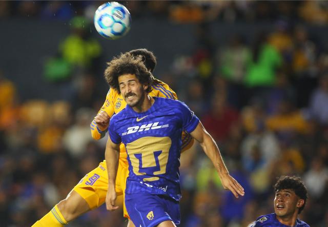 Pumas' defender #02 Pablo Bennevendo (front) and Tigres' Brazilian defender #02 Joaquim Henrique fight for the ball during the Liga MX Clausura tournament football match between Tigres and Pumas at the University  Stadium (UANL) in San Nicolas de los Garza, Mexico on January 14, 2026. (Photo by Julio Cesar AGUILAR / AFP)
