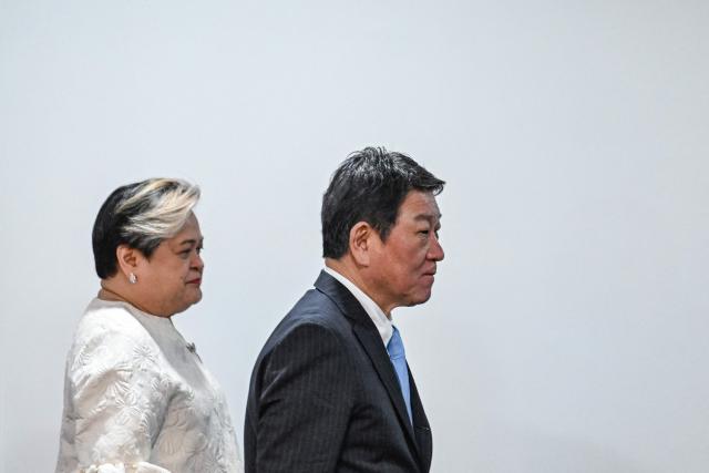 Japan's Foreign Minister Toshimitsu Motegi (R) walks with Philippines' Foreign Minister Theresa Lazaro after a joint press conference in Pasay, Metro Manila on January 15, 2026. (Photo by Jam STA ROSA / AFP)