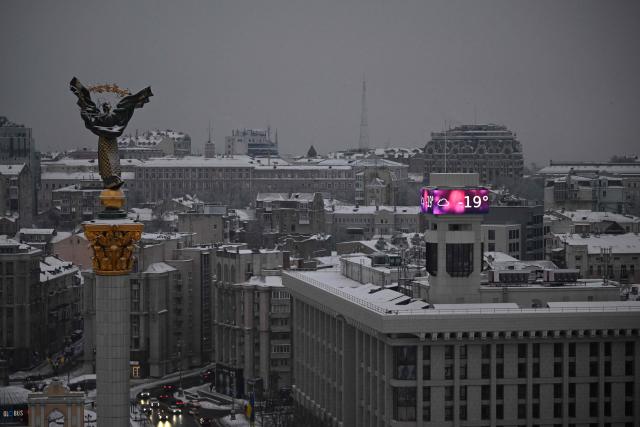 Cars drive along the Independence Square as a big screen on a building displays a temperature of -19 degrees Celsius in Kyiv on January 15, 2026, amid the Russian invasion of Ukraine. Ukraine's President Volodymyr Zelensky said on January 14 a 'state of emergency' will be declared in the energy sector, after relentless Russian strikes on heat and electricity supplies during freezing winter temperatures. (Photo by Sergei GAPON / AFP)