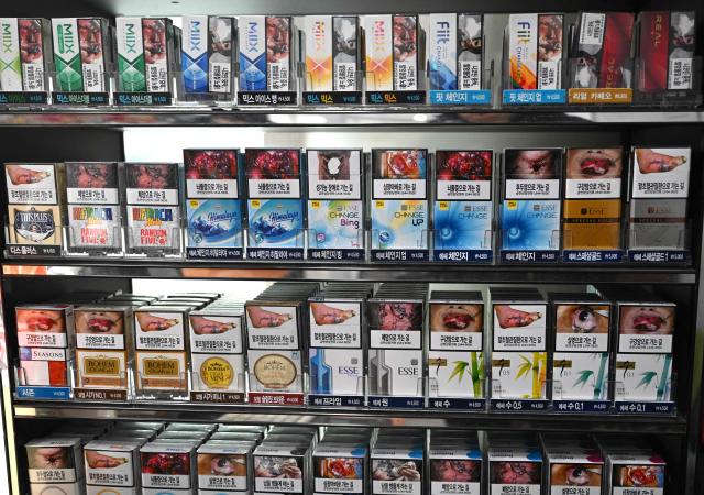 Packs of cigarettes are displayed for sale at a convenience store in Seoul on January 15, 2026. A South Korean court ruled on January 15, against the state health insurer in its lawsuit against the country's three largest tobacco companies over their alleged responsibility for smoking-related harms. (Photo by Jung Yeon-je / AFP)