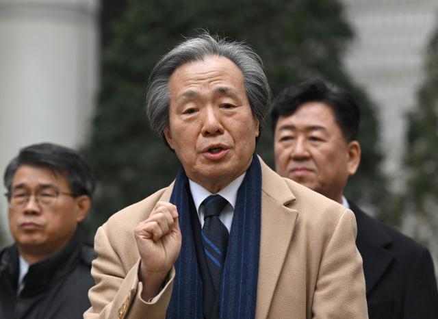 Jung Ki-suck (C), president of the National Health Insurance Service, speaks to reporters after the verdict on South Korea’s tobacco lawsuit at a court in Seoul on January 15, 2026. A South Korean court ruled on January 15, against the state health insurer in its lawsuit against the country's three largest tobacco companies over their alleged responsibility for smoking-related harms. (Photo by Jung Yeon-je / AFP)