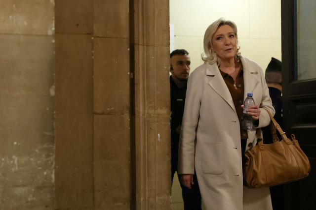 President of the parliamentary group of the French far-right Rassemblement National (RN) party, Marine Le Pen arrives for a hearing in her appeal trial on suspicion of embezzlement of European public funds, at Paris courthouse on January 15, 2026. The appeal comes after a court last year barred the President of the RN parliamentary group Marine Le Pen from running for office for five years over a European Parliament fake-jobs scam involving her and other officials from her National Rally party. The hearing is expected to run until February 11, 2026, with a decision expected this summer. Twelve of the accused, as well as the far-right party itself, have appealed against the verdict while another 12 people -- including one of Le Pen's sisters -- have decided to accept their convictions without appealing. (Photo by Alain JOCARD / AFP)