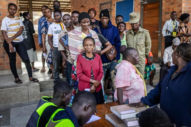 Voters queue to cast their ballots at a polling station amid delays in the start of voting in Kampala on January 15, 2026, during Uganda’s 2026 general elections. (Photo by Luis TATO / AFP)