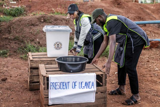 Officials from Uganda’s Electoral Commission set up a voting station amid delays in the start of voting in Kampala on January 15, 2026, during Uganda’s 2026 general elections. (Photo by Luis TATO / AFP)