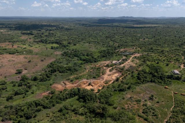 This aerial view shows a mining site next to a forest reserve in Likasi on November 27, 2025. As Chinese, US and other companies jostle over DR Congo’s critical minerals, communities in Haut-Katanga province fear security restrictions or unannounced road constructions in reserves will increase as they seek to protect their land. (Photo by Glody MURHABAZI / AFP)