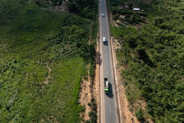 This aerial view shows trucks driving on a road in Likasi on November 27, 2025. As Chinese, US and other companies jostle over DR Congo’s critical minerals, communities in Haut-Katanga province fear security restrictions or unannounced road constructions in reserves will increase as they seek to protect their land. (Photo by Glody MURHABAZI / AFP)