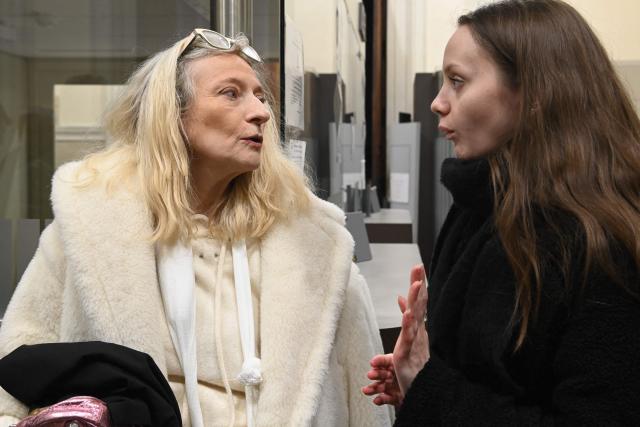 Chloe P. speaks with her lawyer Isabelle Steyer (L) as she waits for the start of the trial of her ex-companion before the Loir-et-Cher Assize Courthouse in Blois, central France on January 15, 2026, after he violently attacked her in December 2022 after she vainly tried to file a complaint. On December 13, 2022, the young woman, then 24 years old, went to the Blois police station to file a complaint against her ex-partner. But on the spot, Chloé P., a manager in a pizzeria, was invited by the police officer to come back the next day. She was found two hours later by the police, alerted by neighbors, left for dead in a pool of blood, in the middle of the common areas of her building. (Photo by JEAN-FRANCOIS MONIER / AFP)