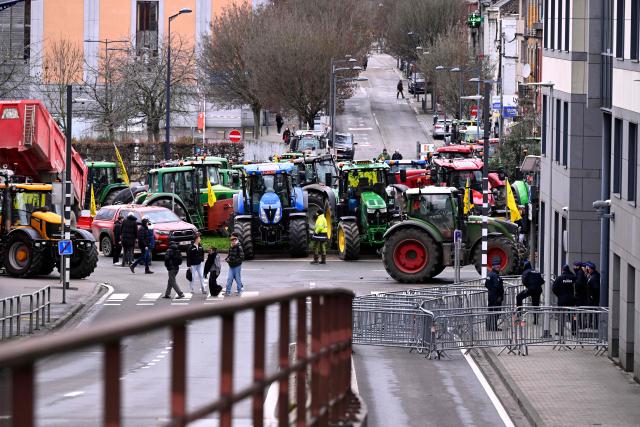 This photograph shows shows tractors parked at a roundabout as part of an action of the farmers to demand measures to support the agricultural sector and protest against the signing of the free trade agreement between the European Union and the Mercosur countries in Namur, on January 15, 2026. (Photo by JOHN THYS / AFP)
