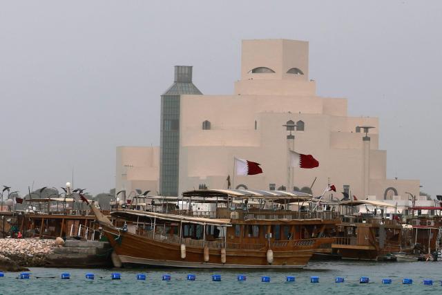 Traditional wooden boats are seen moored in front of the Museum of Islamic Art on a foggy day at the Doha Corniche area in Doha on January 15, 2026. (Photo by Karim JAAFAR / AFP)