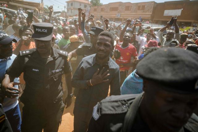Uganda opposition leader and National Unity Platform (NUP) presidential candidate Robert Kyagulanyi Ssentamu, popularly known as Bobi Wine (C), arrives to casts his ballot in Kampala on January 15, 2026, during Uganda’s 2026 general elections. (Photo by Rian COPE / AFP)