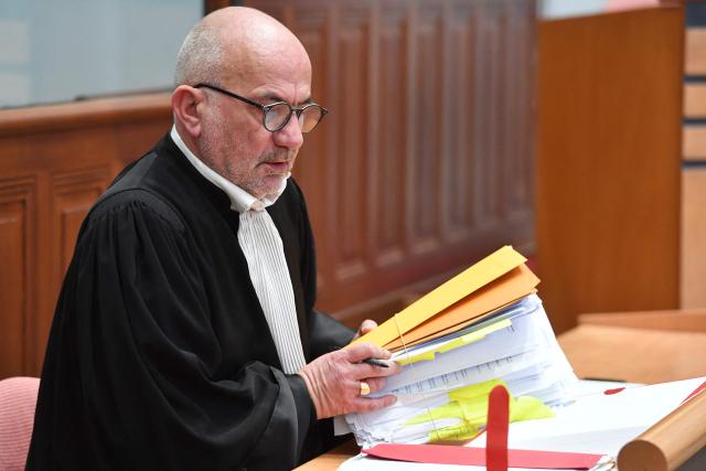 French lawyer for the defendant, Stephane Rapin goes through a folder of documents during the trial of Chloe P's ex-companion tried for attempted murder on Chloe P. before the Loir-et-Cher Assize Courthouse in Blois, central France on January 15, 2026, after he violently attacked her in December 2022. On December 13, 2022, the young woman, then 24 years old, went to the Blois police station to file a complaint against her ex-partner. But on the spot, Chloé P., a manager in a pizzeria, was invited by the police officer to come back the next day. She was found two hours later by the police, alerted by neighbors, left for dead in a pool of blood, in the middle of the common areas of her building. (Photo by JEAN-FRANCOIS MONIER / AFP)