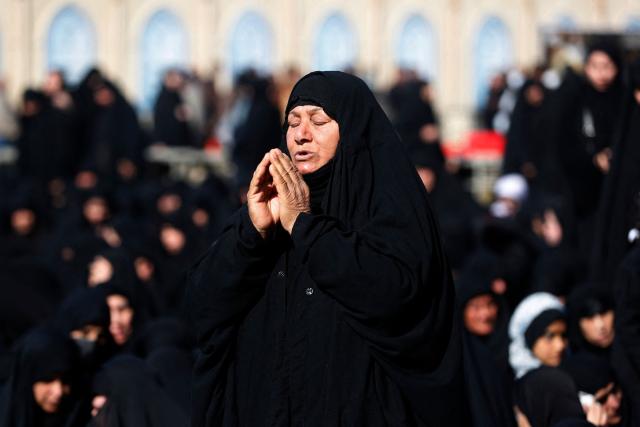 TOPSHOT - A Shiite Muslim pilgrim prays outside the shrine of the 8th-century Imam Musa al-Kadhim, during the annual commemoration of his death on 25 Rajab according to the Muslim Hijri calendar, in the Kadhimiya district of northern Baghdad on January 15, 2026. Pilgrims from various Iraqi provinces annually undertake a march on foot to reach the shrine to commemorate the death of Imam Kadhim, who is believed to have been poisoned by agents of the ruling Abbasid caliph Harun al-Rashid. (Photo by AHMAD AL-RUBAYE / AFP)