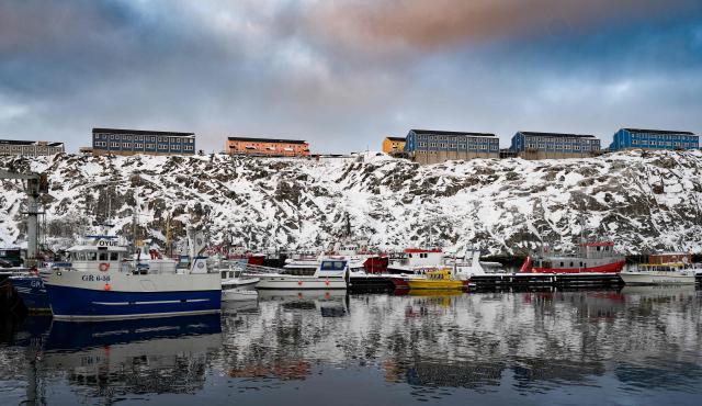 Apartment blocks are seen on a ridge above moored fishing vessels in the harbour in Nuuk, Greenland, on January 15, 2026. Denmark's prime minister said on January 15, 2026 that the US ambition to take control of Greenland remained "intact" and that there were still a "fundamental disagreement" between the countries, despite high-stakes White House talks. (Photo by Alessandro Rampazzo / AFP)