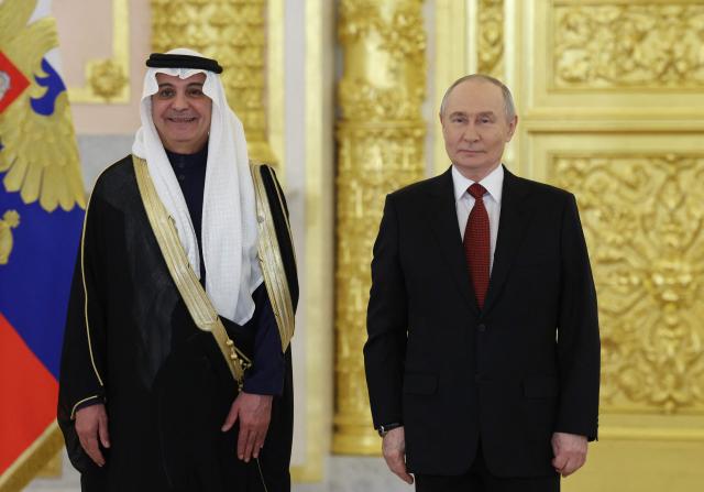 Russia's President Vladimir Putin stands next to Saudi Arabia's Ambassador to Russia Sami Mohammed Al-Sadhan during a ceremony to receive letters of credence from newly appointed foreign ambassadors at the Grand Kremlin Palace in Moscow on January 15, 2026. (Photo by Ramil Sitdikov / POOL / AFP)