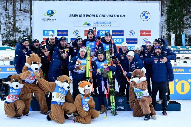 Winners France's Eric Perrot, France's Fabien Claude, France's Quentin Fillon Maillet and France's Oscar Lombardot celebrate on the podium with their tema and mascots after the men's 4x7,5km relay competition of the IBU Biathlon World Cup in Ruhpolding, southern Germany on January 15, 2026. France won the event ahead of Norway and Germany. (Photo by Tobias SCHWARZ / AFP)