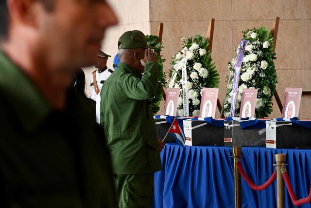 A Cuban soldier salutes the urns with the remains of the 32 Cuban soldiers who died during the US incursion to capture Venezuelan leader Nicolas Maduro, during the funeral honors at the Ministry of the Revolutionary Armed Forces in Havana on January 15, 2026. The capture by US forces of Venezuelan leader Nicolas Maduro on January 3, 2026, and the killing in the operation of 32 Cubans assigned to protect him represent a major blow for the island's revered intelligence services, experts say. (Photo by Yamil LAGE / AFP)