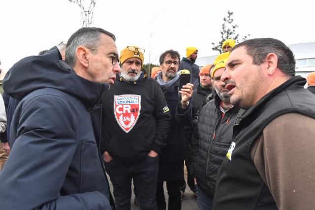 President of Les Republicains (LR) right wing party Bruno Retailleau (L) talks with farmers of the French farmer union Coordination Rurale blocking an oil depot during a protest against the EU-Mercosur trade deal in Saint-Pierre-des-Corps, central France, on January 15, 2026. (Photo by JEAN-FRANCOIS MONIER / AFP)