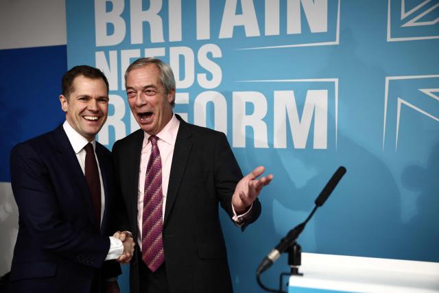 Britain's former Conservative Party Shadow Justice Secretary Robert Jenrick shakes hands with Reform UK leader, Nigel Farage, after announcing his defection to Reform, during a press conference, in central London on January 15, 2026. (Photo by Henry NICHOLLS / AFP)