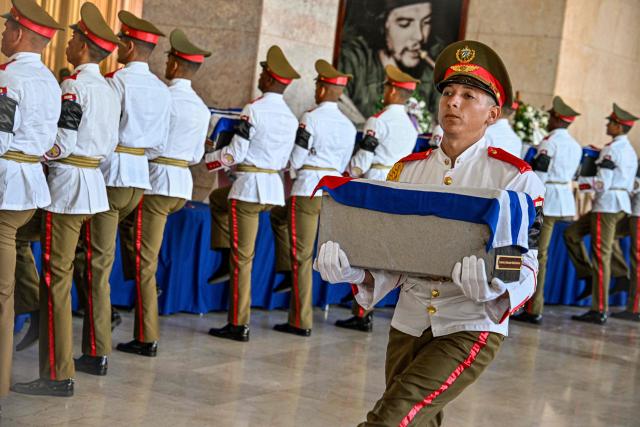 A Cuban guard of the Ceremonial Battalion carry the urns with the remains of the 32 Cuban soldiers who died during the US incursion to capture Venezuelan leader Nicolas Maduro, during the funeral honors at the Ministry of the Revolutionary Armed Forces in Havana on January 15, 2026. The capture by US forces of Venezuelan leader Nicolas Maduro on January 3, 2026, and the killing in the operation of 32 Cubans assigned to protect him represent a major blow for the island's revered intelligence services, experts say. (Photo by ADALBERTO ROQUE / POOL / AFP)