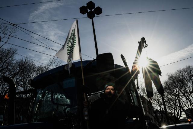 TOPSHOT - A farmer drives his tractor parked in a street of Lyon during a protest against the EU-Mercosur trade deal in Lyon on January 15, 2026. (Photo by JEFF PACHOUD / AFP)