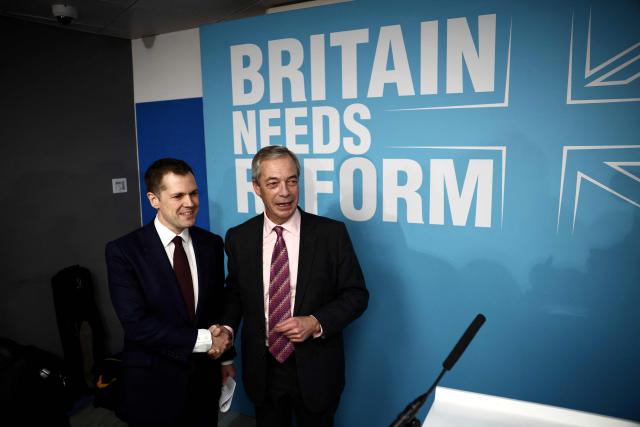 Britain's former Conservative Party Shadow Justice Secretary Robert Jenrick shakes hands with Reform UK leader, Nigel Farage, before announcing his defection to Reform during a press conference, in central London on January 15, 2026. (Photo by Henry NICHOLLS / AFP)