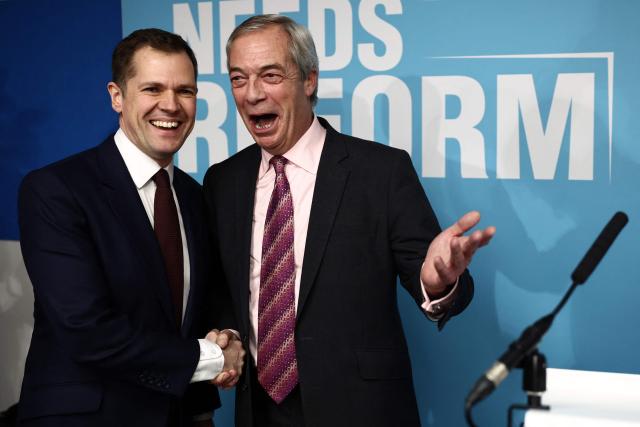 Britain's former Conservative Party Shadow Justice Secretary Robert Jenrick shakes hands with Reform UK leader, Nigel Farage, before announcing his defection to Reform, during a press conference, in central London on January 15, 2026. (Photo by Henry NICHOLLS / AFP)