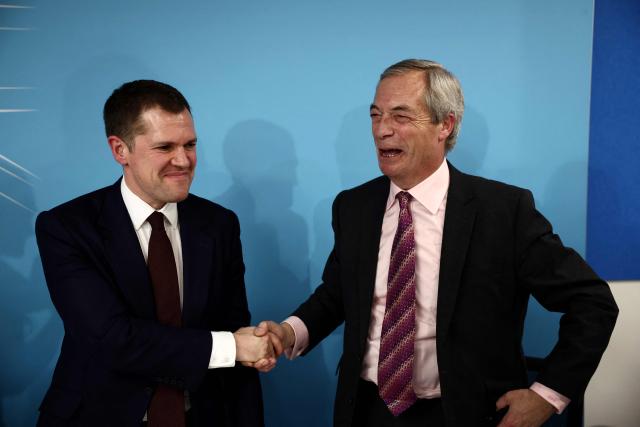 Britain's former Conservative Party Shadow Justice Secretary Robert Jenrick shakes hands with Reform UK leader, Nigel Farage, after announcing his defection to Reform, during a press conference, in central London on January 15, 2026. (Photo by Henry NICHOLLS / AFP)
