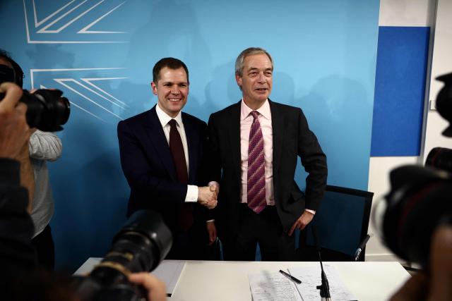 Britain's former Conservative Party Shadow Justice Secretary Robert Jenrick shakes hands with Reform UK leader, Nigel Farage, after announcing his defection to Reform, during a press conference, in central London on January 15, 2026. (Photo by Henry NICHOLLS / AFP)
