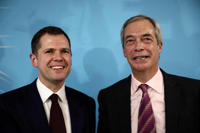 Britain's former Conservative Party Shadow Justice Secretary Robert Jenrick reacts with Reform UK leader, Nigel Farage, after announcing his defection to Reform, during a press conference, in central London on January 15, 2026. (Photo by Henry NICHOLLS / AFP)