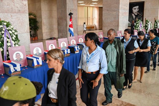 Cubans pay their respects during the funeral honors of the 32 Cuban soldiers who died during the US incursion to capture Venezuelan leader Nicolas Maduro, at the Ministry of the Revolutionary Armed Forces in Havana on January 15, 2026. The capture by US forces of Venezuelan leader Nicolas Maduro on January 3, 2026, and the killing in the operation of 32 Cubans assigned to protect him represent a major blow for the island's revered intelligence services, experts say. (Photo by YAMIL LAGE / AFP)