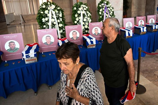 Cubans pay their respects during the funeral honors of the 32 Cuban soldiers who died during the US incursion to capture Venezuelan leader Nicolas Maduro, at the Ministry of the Revolutionary Armed Forces in Havana on January 15, 2026. The capture by US forces of Venezuelan leader Nicolas Maduro on January 3, 2026, and the killing in the operation of 32 Cubans assigned to protect him represent a major blow for the island's revered intelligence services, experts say. (Photo by YAMIL LAGE / AFP)