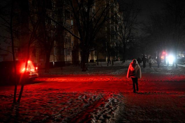 Pedestrians walk along a street during a power outage in Kyiv on January 15, 2026, amid the Russian invasion of Ukraine. (Photo by Sergei GAPON / AFP)