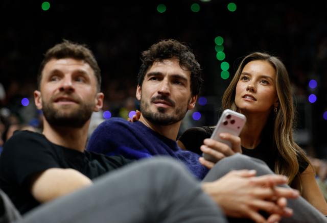 Former German football defender Mats Hummels (C), German footballer Thomas Mueller (L) and German model Nicola Cavanis attend the 2025/2026 NBA season basketball match between Memphis Grizzlies and Orlando Magic on January 15, 2026 in Berlin. (Photo by Odd ANDERSEN / AFP)