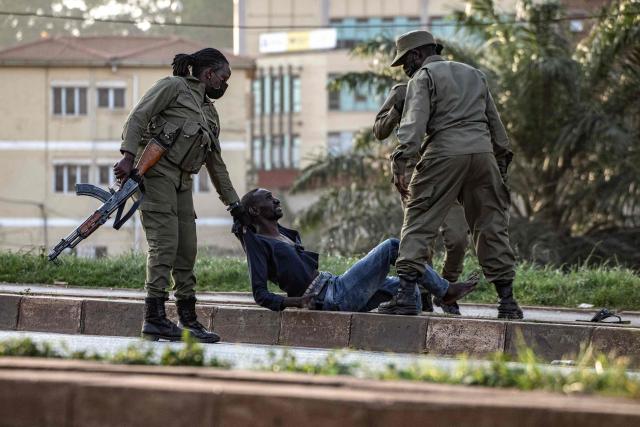 TOPSHOT - Police officers detain a voter on the ground near a polling station in Kampala on January 15, 2026, during Uganda's 2026 general elections. Polls closed in Uganda on January 15, 2026 after a chaotic day of voting that took place under an internet blackout and with long delays caused by technical breakdowns as President Yoweri Museveni seeks to extend his 40 years in power. Museveni, an 81-year-old who came to power at the head of a rebel army in 1986, is widely expected to win a seventh term in office thanks to his total control of the state and security apparatus. (Photo by BADRU KATUMBA / AFP)