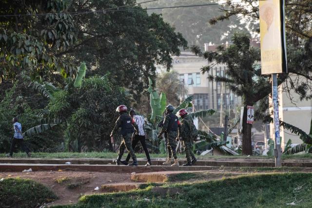 Ugandan military police officers detain a voter on the ground near a polling station in Kampala on January 15, 2026, during Uganda's 2026 general elections. Polls closed in Uganda on January 15, 2026 after a chaotic day of voting that took place under an internet blackout and with long delays caused by technical breakdowns as President Yoweri Museveni seeks to extend his 40 years in power. Museveni, an 81-year-old who came to power at the head of a rebel army in 1986, is widely expected to win a seventh term in office thanks to his total control of the state and security apparatus. (Photo by BADRU KATUMBA / AFP)