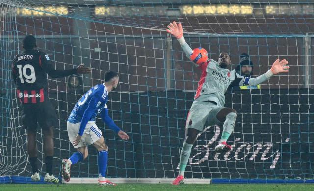 AC Milan's French goalkeeper #16 Mike Maignan make a save during the Italian Serie A football match between Como and AC Milan at Giuseppe Sinigaglia stadium in Como, on January 15, 2026. (Photo by Stefano RELLANDINI / AFP)