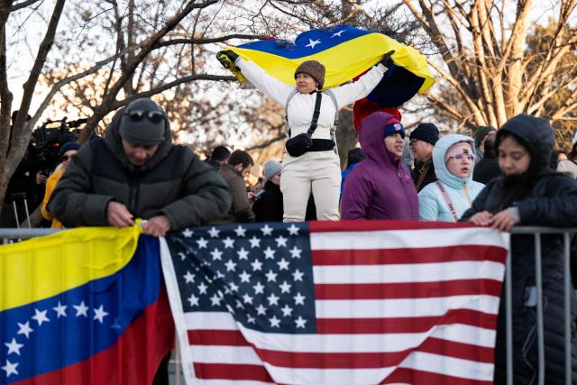 A woman waves a Venezuelan flag as she waits for opposition leader Maria Corina Machado to exit the US Capitol following a meeting with US senators on January 15, 2026 in Washington, DC. US President Donald Trump met earlier Thursday with Venezuelan opposition leader Machado, whose pro-democracy movement he has sidelined since toppling her country's leader, and whose Nobel Peace Prize he openly envies. (Photo by Drew ANGERER / AFP)