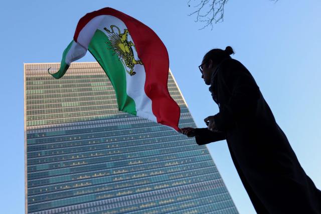 A protester waves the Iranian flag outside UN headquarters during a United Nations Security Council meeting on Iran in New York on January 15, 2026. The United States on Thursday said Iran halted 800 executions of protesters under pressure from President Donald Trump, after Gulf allies appeared to pull him back from military action over Tehran's deadly crackdown on demonstrations. Iran was shaken over the last week by some of the biggest anti-government protests in the history of the Islamic republic, although the demonstrations appear to have diminished over the last few days in the face of repression and a week-long internet blackout. (Photo by ANGELA WEISS / AFP)