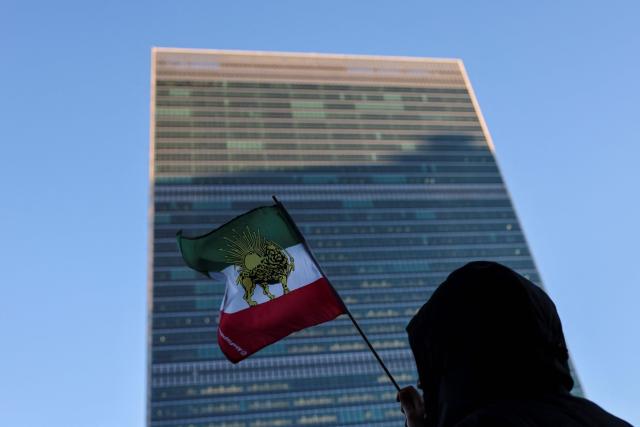 A protester waves the Iranian flag outside UN headquarters during a United Nations Security Council meeting on Iran in New York on January 15, 2026. The United States on Thursday said Iran halted 800 executions of protesters under pressure from President Donald Trump, after Gulf allies appeared to pull him back from military action over Tehran's deadly crackdown on demonstrations. Iran was shaken over the last week by some of the biggest anti-government protests in the history of the Islamic republic, although the demonstrations appear to have diminished over the last few days in the face of repression and a week-long internet blackout. (Photo by ANGELA WEISS / AFP)