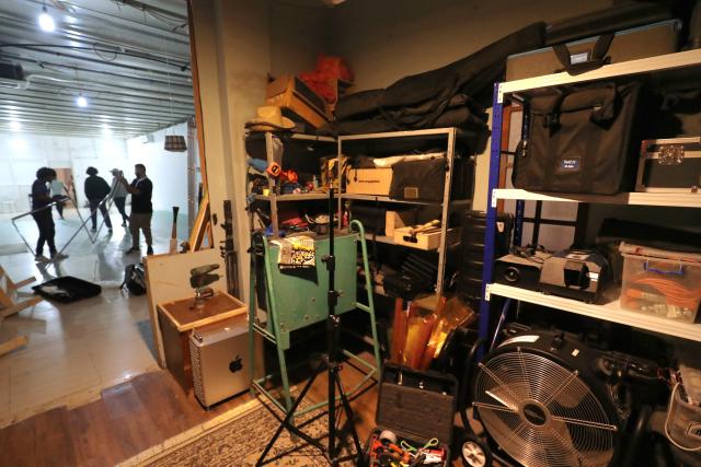 Members of the crew prepare their equipment prior to filming in studios built inside the home of the Libyan filmmaker in Tripoli on October 19, 2025. Mouayed Zabtia, 47, shoots most scenes for his latest movie in a studio he built at his Tripoli home. For the filmmaker, it is one way to overcome the obstacles he faces in a country where cinema once nearly vanished. Before a 1969 coup that brought longtime ruler Moamer Kadhafi to power, Libya's capital Tripoli was home to more than 20 movie theatres. Today, Zabtia said, it is no longer censorship that stifles filmmaking in Libya, but an array of other challenges compounded by a lack of public support. (Photo by Mahmud TURKIA / AFP)