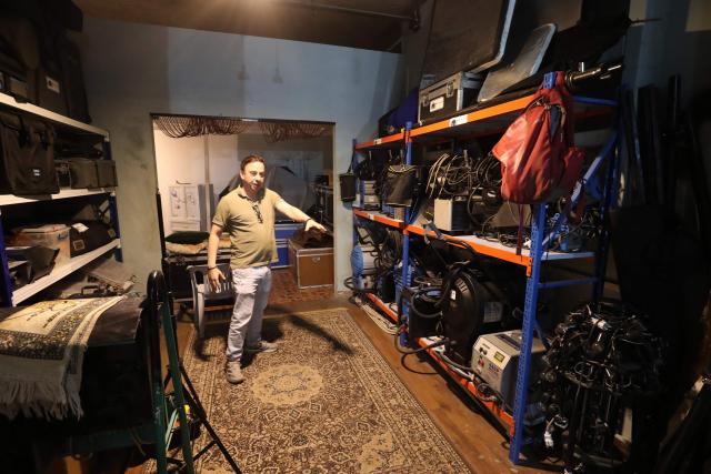 Libyan filmaker Mouayed Zabtia stands next to his equipment in his home-come-studio, in Tripoli on October 19, 2025. Mouayed Zabtia, 47, shoots most scenes for his latest movie in a studio he built at his Tripoli home. For the filmmaker, it is one way to overcome the obstacles he faces in a country where cinema once nearly vanished. Before a 1969 coup that brought longtime ruler Moamer Kadhafi to power, Libya's capital Tripoli was home to more than 20 movie theatres. Today, Zabtia said, it is no longer censorship that stifles filmmaking in Libya, but an array of other challenges compounded by a lack of public support. (Photo by Mahmud TURKIA / AFP)