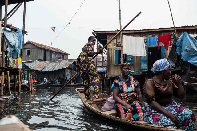 People in a pirogue navigate their way in Makoko, a floating slum in Lagos, on January 9, 2026. Authorities have demolished hundreds of wooden shacks in Makoko, Africa’s largest and most iconic floating slum, which is built on stilts above the lagoon in the heart of Lagos. The operation is part of an ongoing campaign to remove what officials describe as illegal structures and reclaim waterfront land for modern real-estate developments. (Photo by TOYIN ADEDOKUN / AFP)